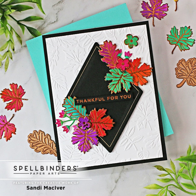 handmade greeting card with fall colored foiled leaves on a white embossed background using card making products from Spellbinders