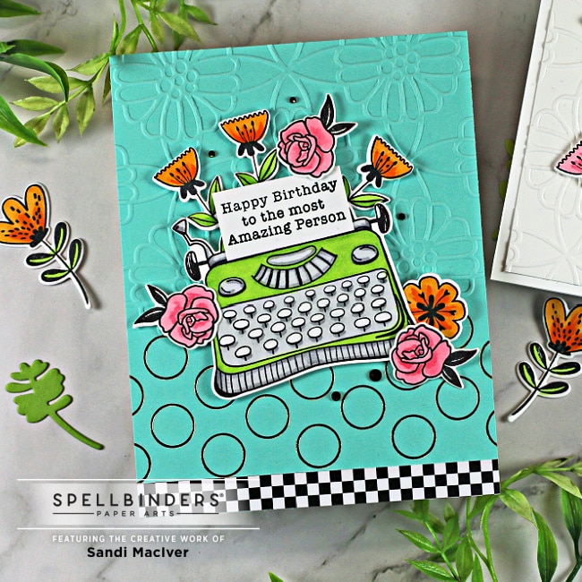 turquoise hand made card with a lime green typewriter and orange flowers created with new card making products from Spellbinders