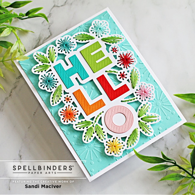handmade greeting card in a rainbow of colors with a stitched border around the die cut sentiment created with new card making dies from Spellbinders