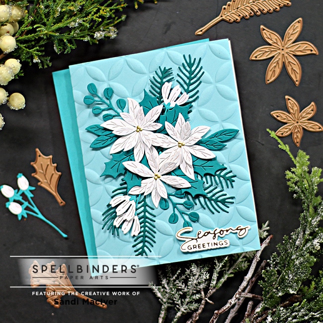 handmade christmas card in shades of teal with white poinsettias and a glimmer foiled sentiment using new card making supplies from Spellbinders