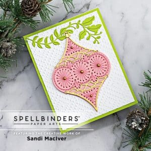 handmade christmas card with a pink stitched ornament on a white background and a lime green branch created with new card making supplies from Spellbinders