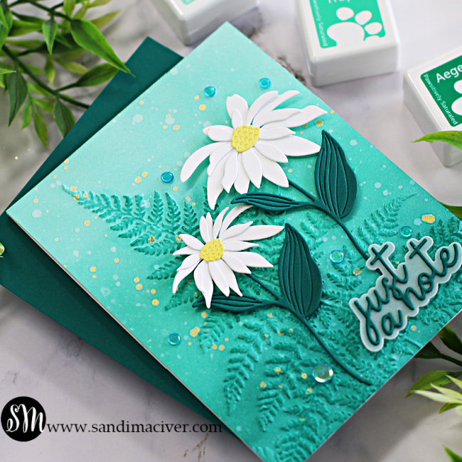hand made greeting card with a blue green embossed background and white daisies created with new card making supplies from Simon Says Stamp