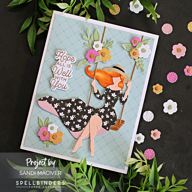 hand made die cut card with a girl on a swing and floral accents created with card making supplies from Spellbinders