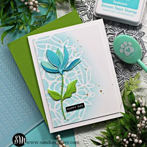 white handmade card with a blue stenciled mandala in the background and a die cut blue and green flower overlay created with new card making products from Simon Says Stamp