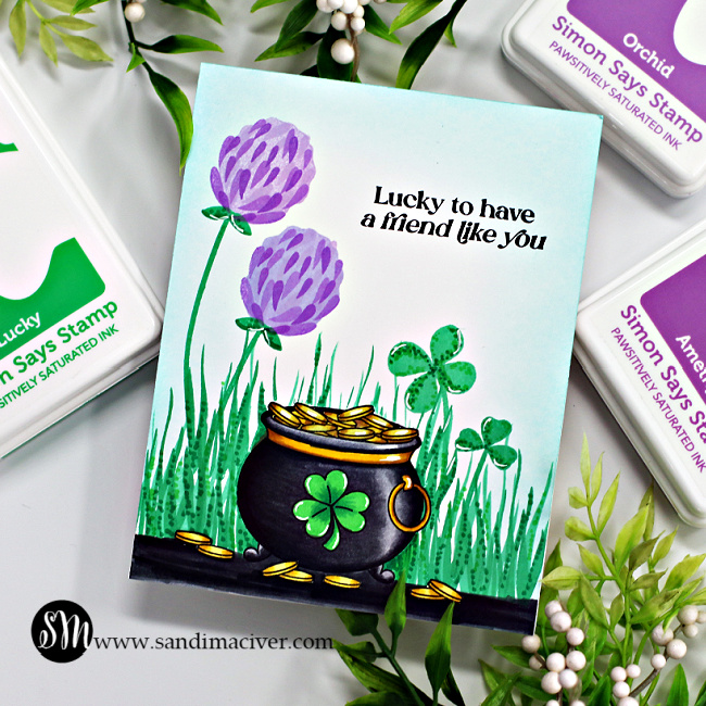 hand made card with a black pot of gold full of gold coins, sitting amongst grass and clover, including a 4 leaf clover, created with new card making supplies from Simon Says sTamp