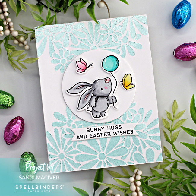 hand made Easter card with a pale blue floral background and a gray bunny holding a blue balloon with pink and yellow butterflies, created with new card making products from Spellbinders