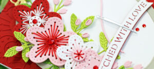 red pink and white hand made greeting card with stitched flowers and a wood looking embossing ring created with new card making supplies from SPellbinders