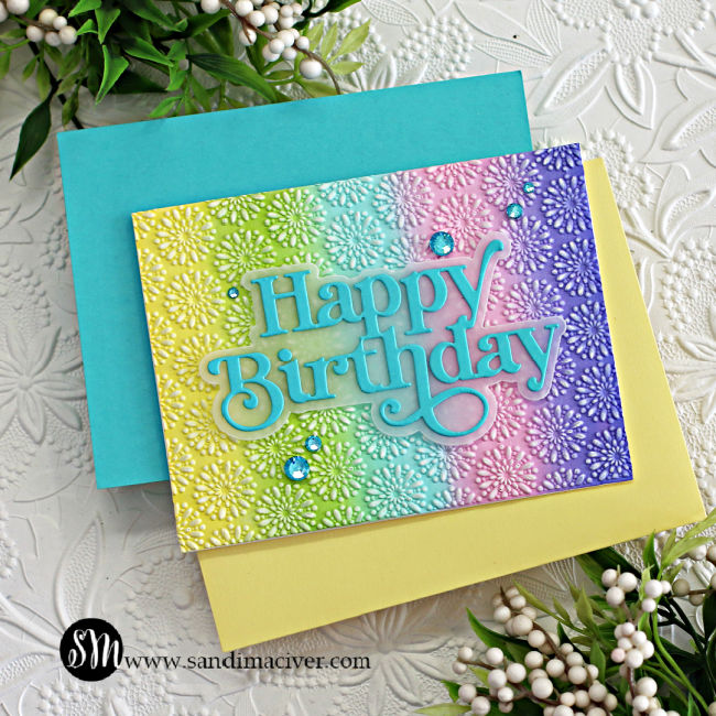 hand made birthday card with a rainbow of colors across the front and embossed with a flower design created with new card making products from Simon Says Stamp