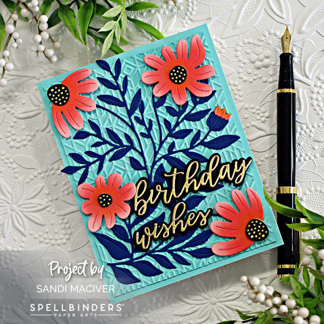 hand made card with a teal blue background, dark blue leaves and orange flowers created with card making supplies from Spellbinders
