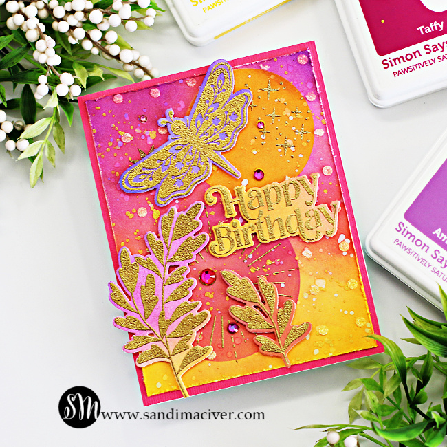 handmade birthday card with a pink and yellow ink blended background and overlay of gold embossed leaves and dragonfly created with card making supplies from Simon Says Stamp