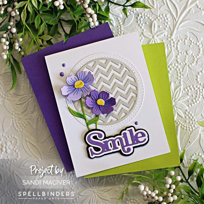 white hand made card with a gray circle background and purple die cut Anemone with green stems created with card making supplies from Spellbinders 