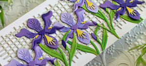 white slimline card covered in purple die cut Iris created with new card making supplies from Spellbinders