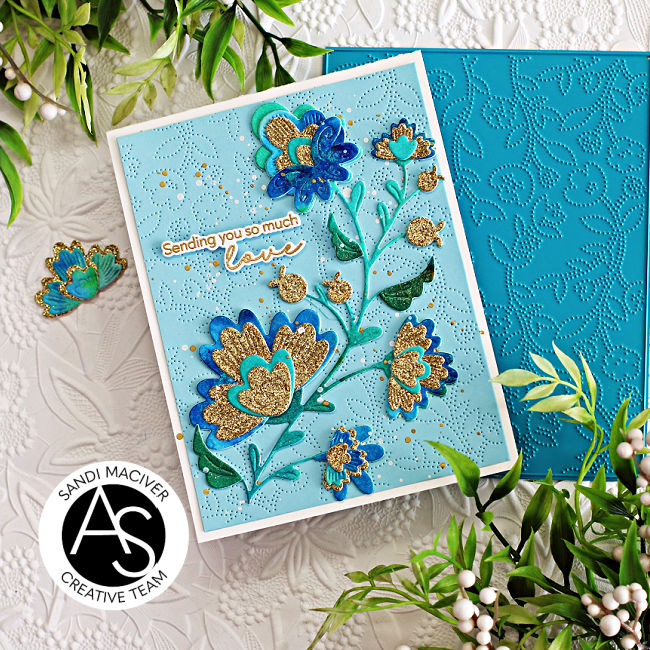 hand made greeting card with a embossed blue background and a die cut floral stem in greens blues and golds created with new card making products from Alex Syberia Designs