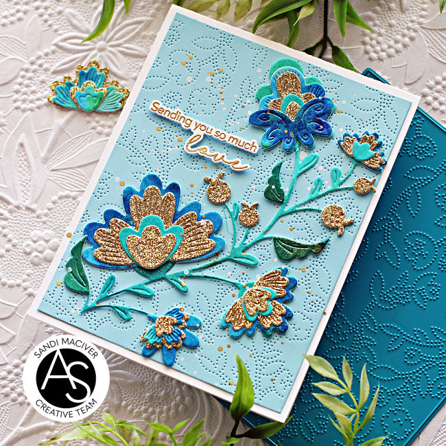 hand made greeting card with a embossed blue background and a die cut floral stem in greens blues and golds created with new card making products from Alex Syberia Designs