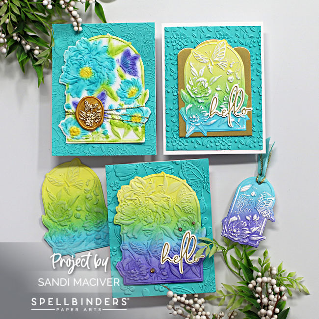 3 hand made cards and two tags in blues, greens, purples and yellows created with new card making supplies from Spellbinders