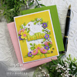 hand made white and yellow card with an arch cut in the center surrounded by pink yellow and purple die cut flowers created with new card making supplies from Spellbinders