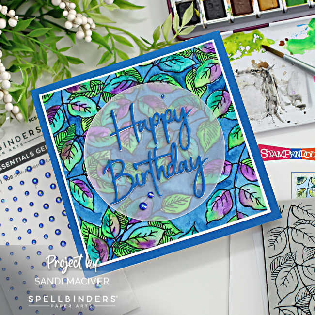 hand made square card with blue, purple, and green leaves with a dark blue background and a happy birthday sentiment in the center on top of a circle of vellum.