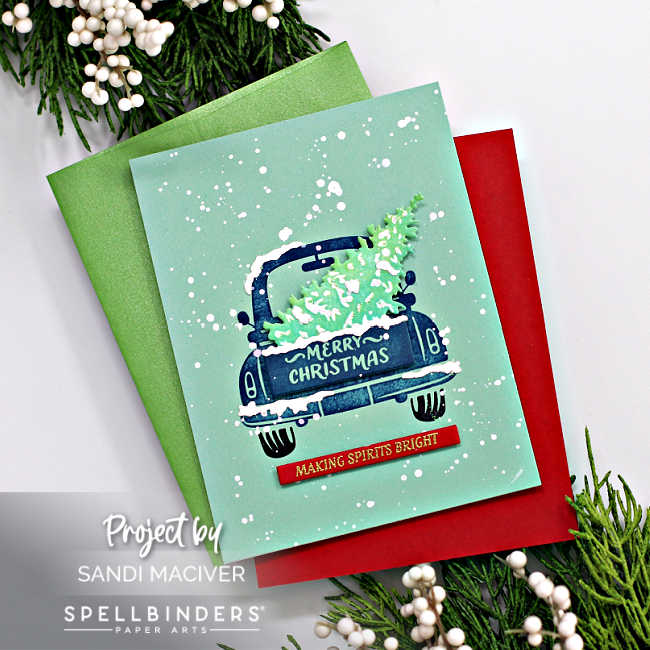 hand made christmas card with a mint background, a faded dark blue vintage truck with a cut christmas tree in the back.