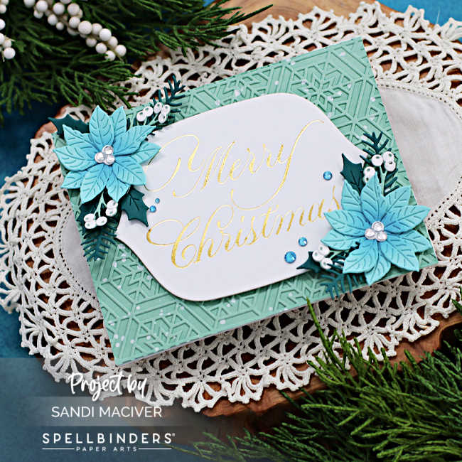 hand made Christmas card with a pale mint embossed background a white mid section with a beautiful copperplate font sentiment and embellished with blue poinsettia die cuts and dark green foliage cut using new card making supplies from Spellbinders