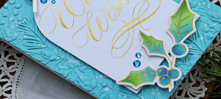 More Christmas in July, hand made christmas card with a turquoise background, a gold plated sentiment and blue and green die cut holly