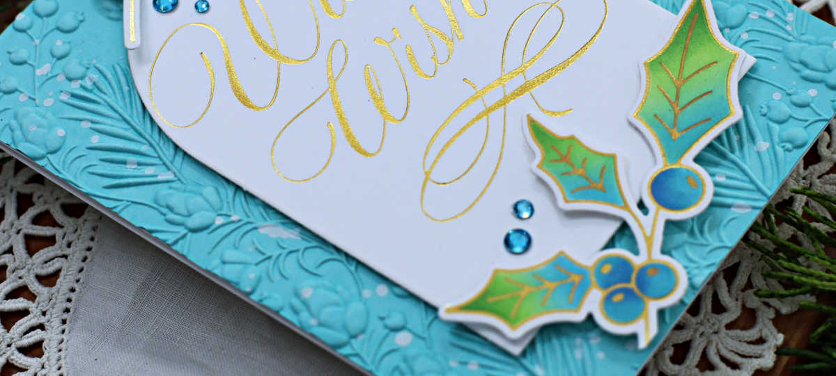 More Christmas in July, hand made christmas card with a turquoise background, a gold plated sentiment and blue and green die cut holly 