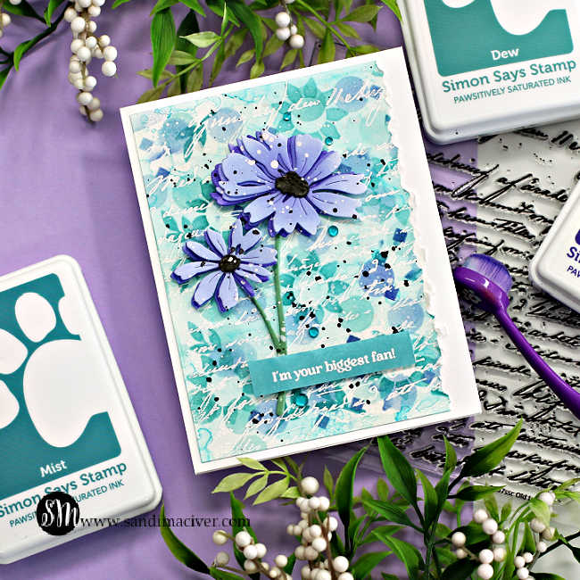 hand made card with a stenciled background in teal and purple with two die cut purple flowers overlaid