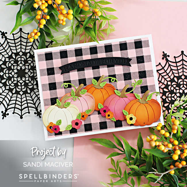 Pink and Black Halloween card with a buffalo plaid background and pink, orange and vanilla pumpkins decorated with leaves and flowers