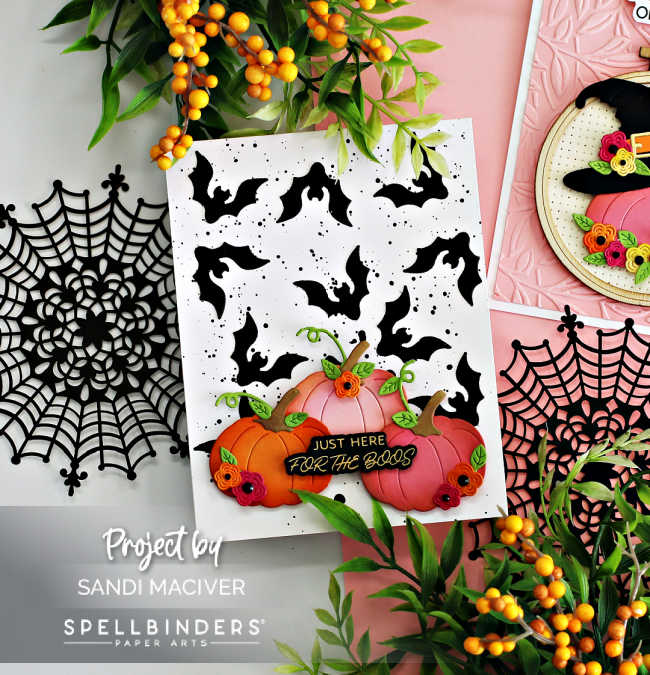 hand made halloween card with a white base covered in black bats, pink and orange pumpkins decorated in fall colored flowers