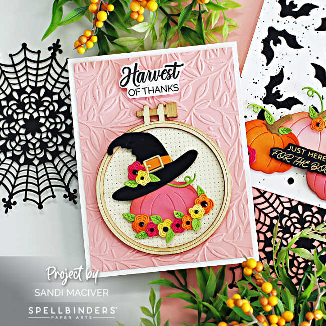 hand made fall card with a pink and white background and a pink pumpkin with a witches hat on top, decorated with fall colored flowers