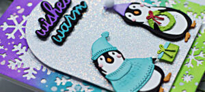 Christmas cards in purple, teal and green with little penguins dressed up for winter in sweaters and touques