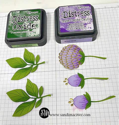 image shows purple flowers and green leaves and the two ink colors used to add shadows and highlights to the die cut pieces