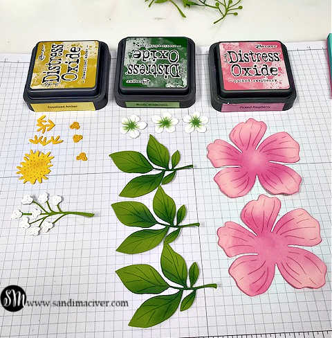 yellow green and pink ink pads above die cut flowers and leaves showing them ink blended with the inks