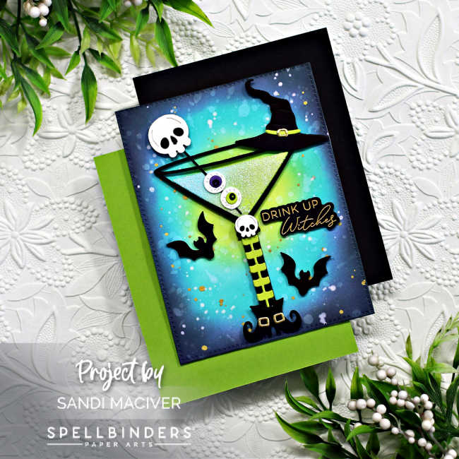 Halloween themed hand made card with a green martini decorated with eye balls, skeletons and a witches hat, with a green blue and purple ink blended background