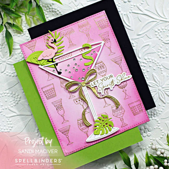 hand made card with a white die cut martini glass on a pink and gold embossed background with a lime wedge and curl and a flamingo stir stick