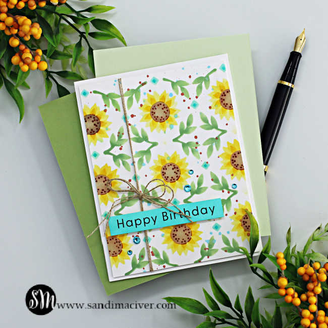 Hand made birthday card with stenciled sunflowers and leaves on a white card base with jute rope tied down the left side to a bow and a turquoise sentiment.