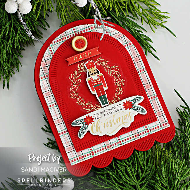 red handmade christmas card with an arch and a nutcracker in a wreath on the front 