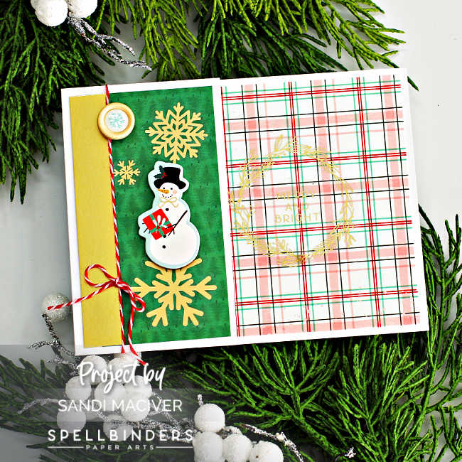 hand made christmas card with a pink and green plaid background and gold snowflake stickers.