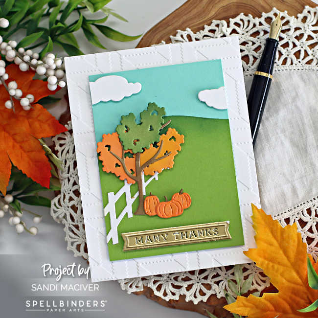 hand made die cut card with a outdoor fall scene in a field with a blue sky and clouds, a tree in fall colors with pumpkins underneath