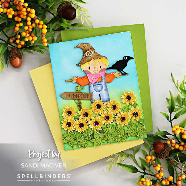 handmade die cut fall card with a field of sunflowers and a black grown sitting on the arm of a scarecrow with a turquoise sky behind