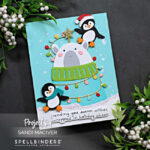 hand made christmas card with a bear in a turquoise sweater being decorated with lights by two penguins