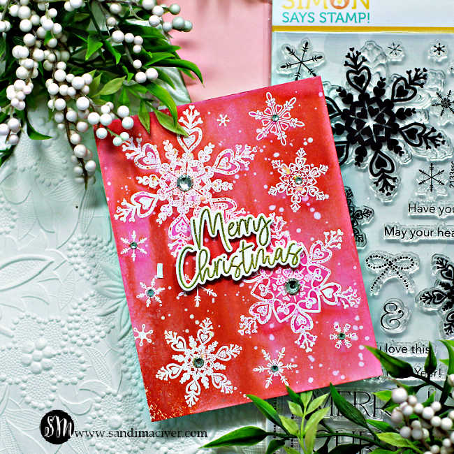 pink and orange hand made Christmas card covered in white embossed snowflakes