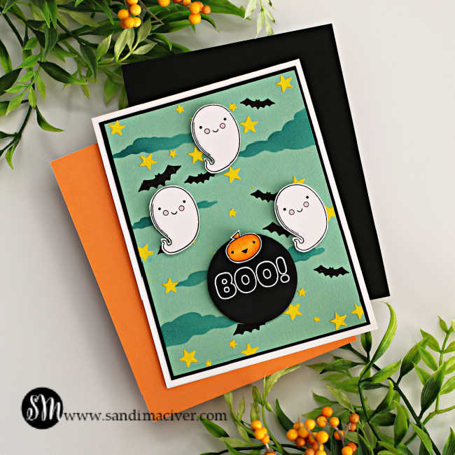 hand made Haloween card with a mint green background, blue clouds and yellow stars with three ghosts