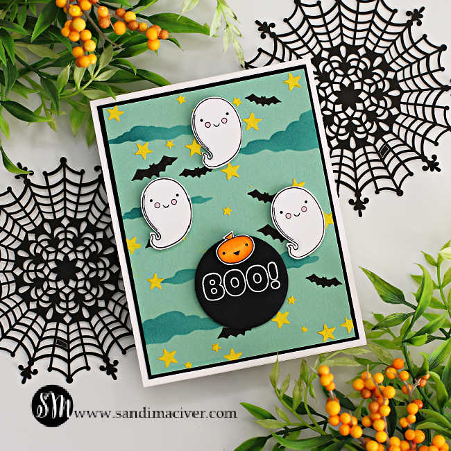 hand made Halloween card with a mint green background, blue clouds and yellow stars with three ghosts