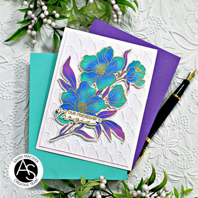 hand made friendship card with blue and green flowers with purple leaves on a white embossed background