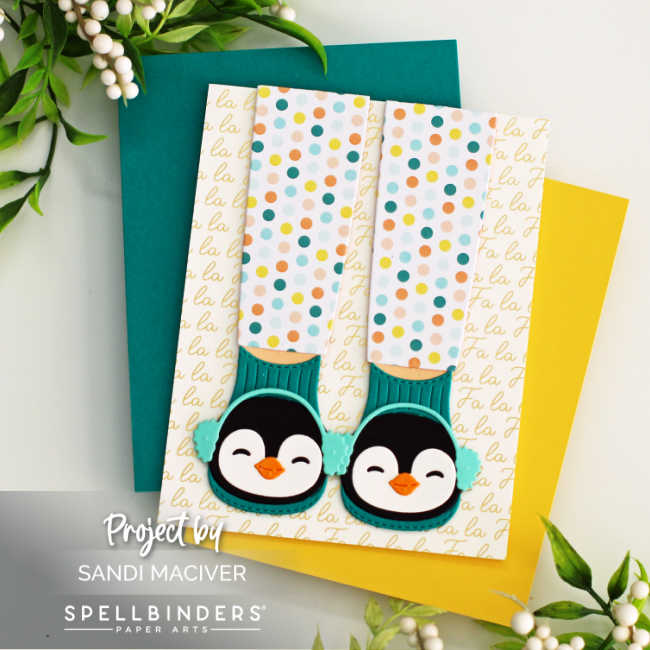 hand made christmas card with gold falala words across the background and legs with feet in fuzzy slippers with penguins on the front