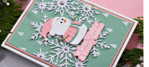 hand made mint green and pink christmas card with a white snowflake background and a tiny die cut snowman with a pink and green sweater and hat