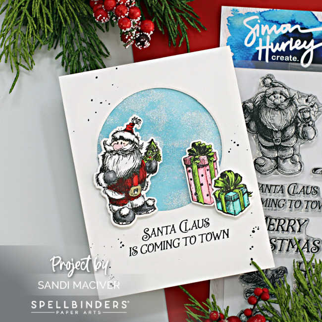 white hand made christmas card with a circle cut out and glitter shaker inside with a hand sketched santa overlay and pink and turquoise parcels