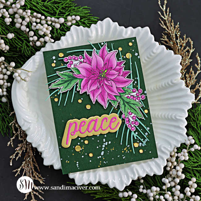 hand made christmas card with a dark green background splattered with white and gold paint, and overlay of a pink poinsettia spray with mint green leaves and a die cut sentiment saying peace.