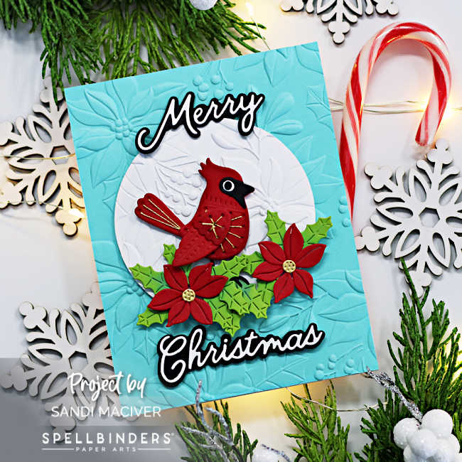 hand made christmas card with a die cut and stitched cardinal atop some red and green foliage on a teal card base.