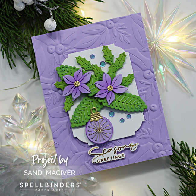 hand made purple christmas card with an embossed background with a white panel overlay embellished with green and purple stitched leaves and christmas ornaments